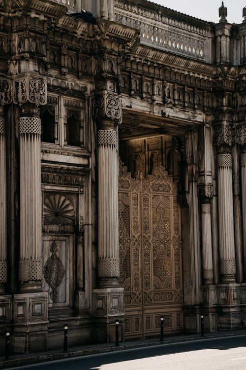 Free Majestic facade featuring detailed columns and an ornate entrance in a vintage architectural style. Stock Photo