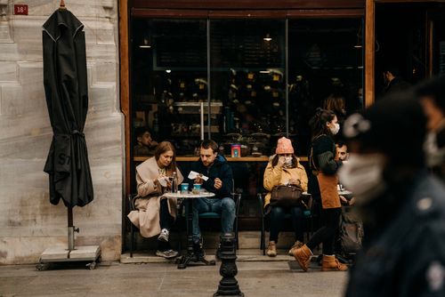 Free People enjoying meals and coffee outside a café with a bustling sidewalk scene. Stock Photo