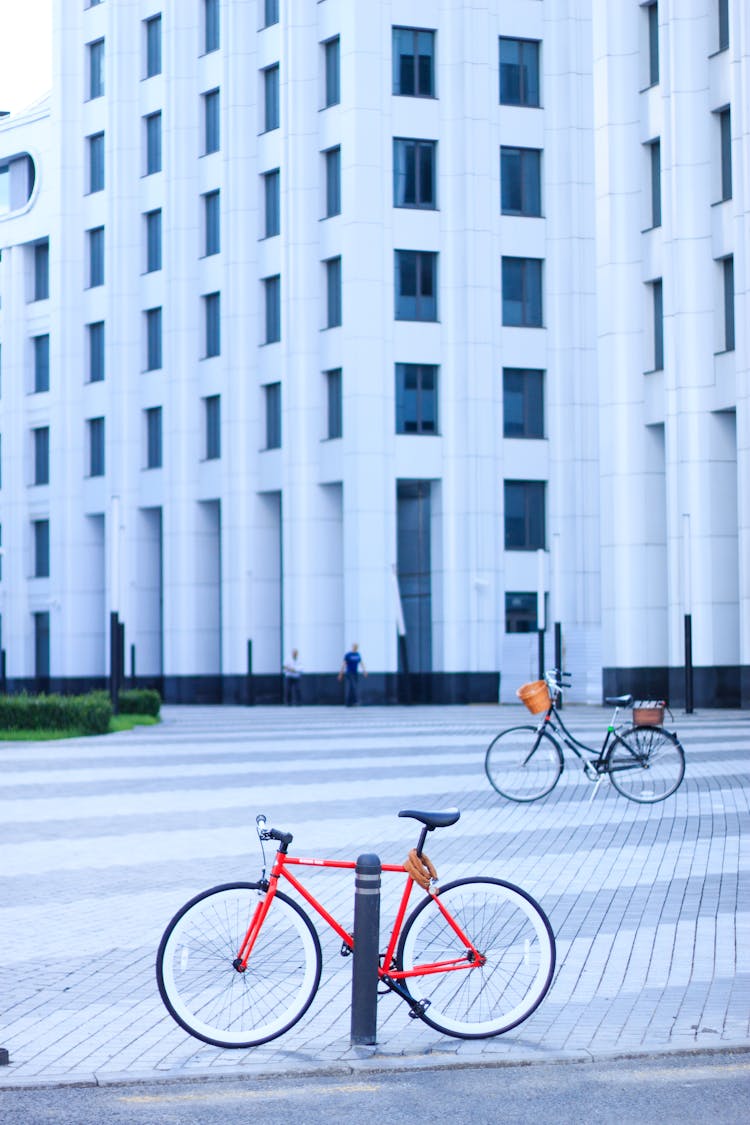 Bicycles Parked On Paved Floor Near A White Building