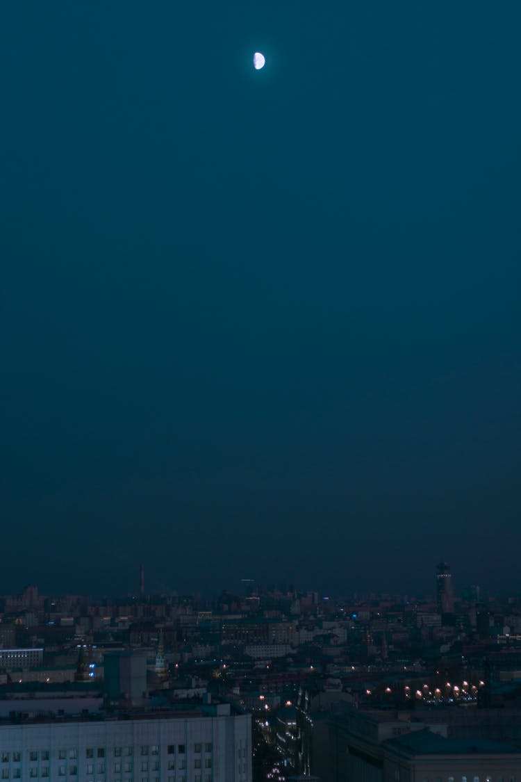 Blue Toned Photo Of A Night City Sky With Moon