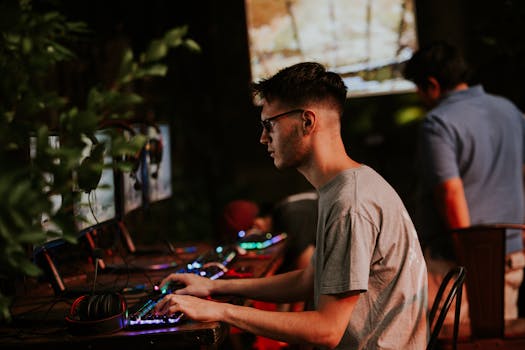 Young man gaming intensely at a Cyber Lounge with colorful RGB lighting.