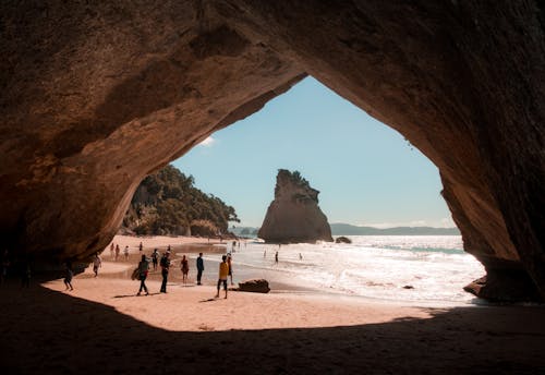 無料 洞窟と水域の横を歩いている人 写真素材