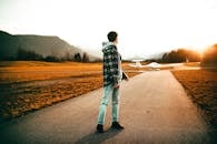 在德国奥尔施塔特，一名身穿休闲装的男子站在路边，看着日落时分的飞机