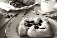 黑白图像中的美味早餐糕点和咖啡，营造出经典的早晨氛围