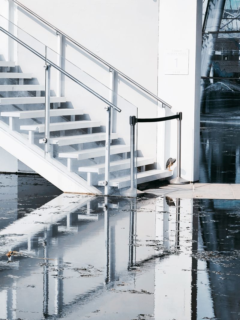 Standing water covering a floor at the foot of a staircase
