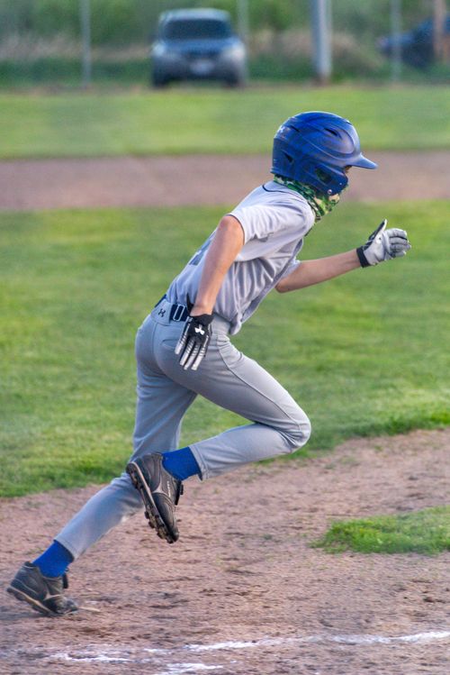 Free Action shot of a teenager running on the baseball field during a game. Stock Photo