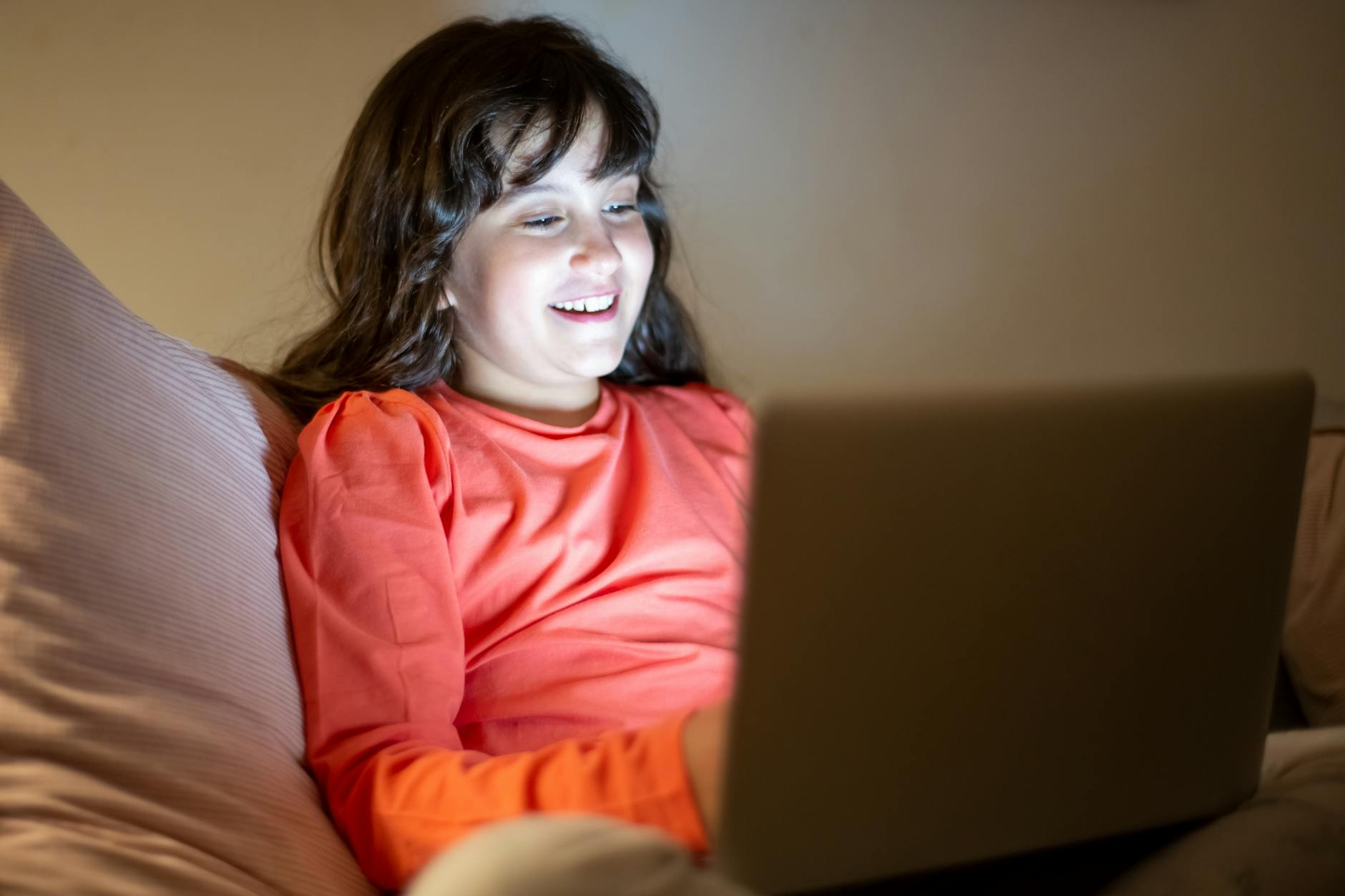 Girl in Orange Long Sleeves Using a Laptop