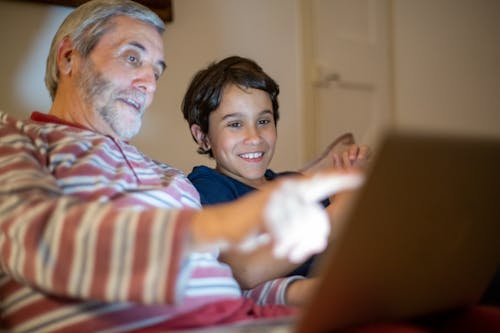 Free An Elderly Man and a Boy Using a Laptop Stock Photo