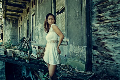 Foto De Mulher Usando Vestido Branco Em Pé Perto De Um Prédio Abandonado