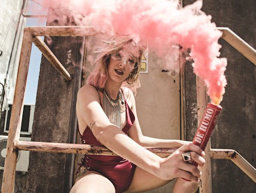 Woman in Maroon Monokini Holding Dynamite