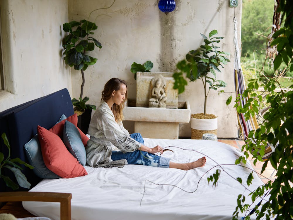 Free Woman in White Long Sleeve Shirt Sitting on Bed Stock Photo