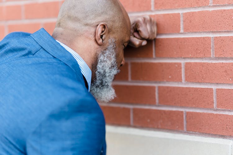 Tired Black Worker Near Brick Wall