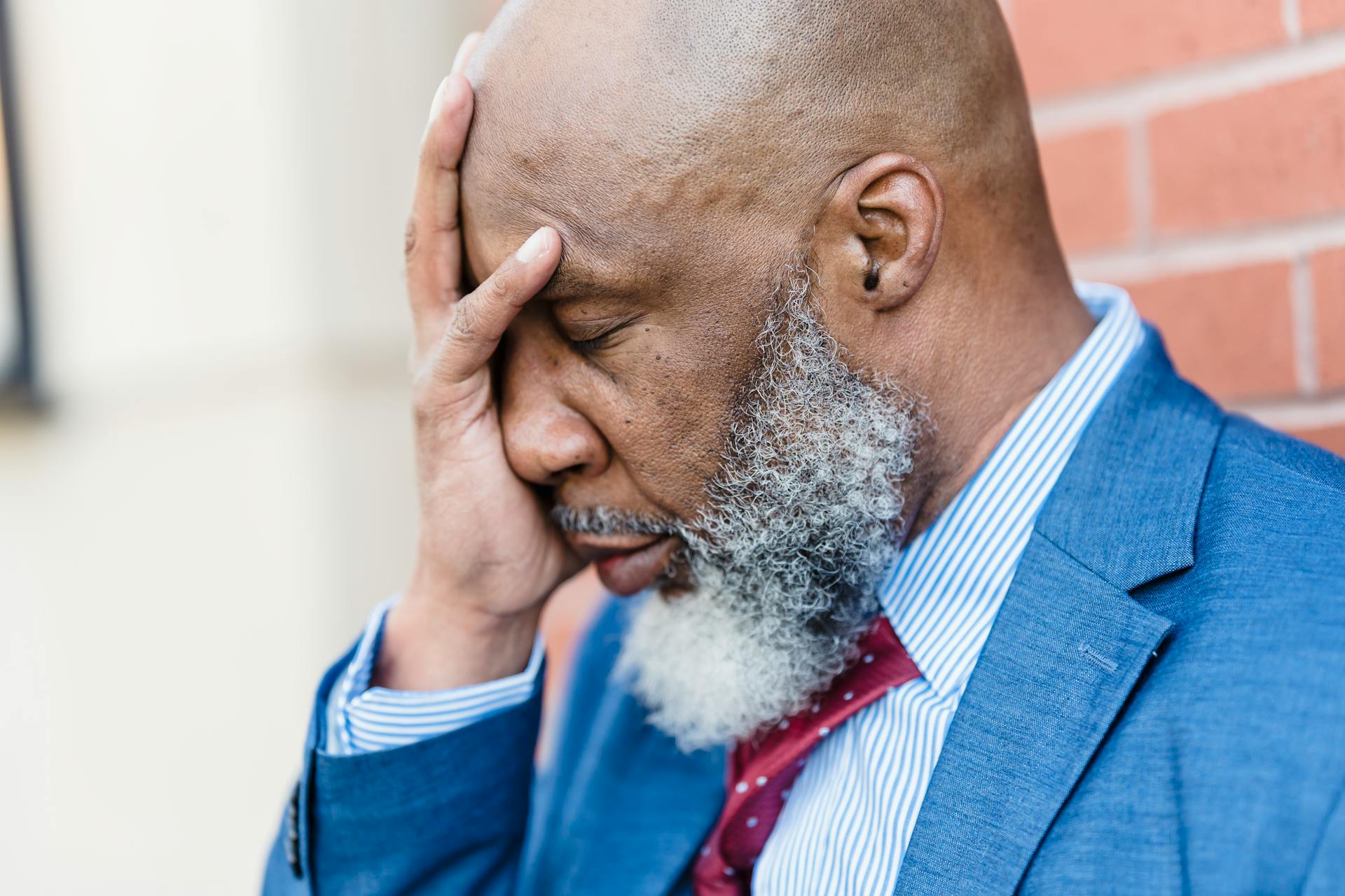 Upset black businessman with hand on face