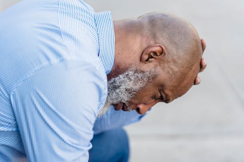 Depressed black businessman on street