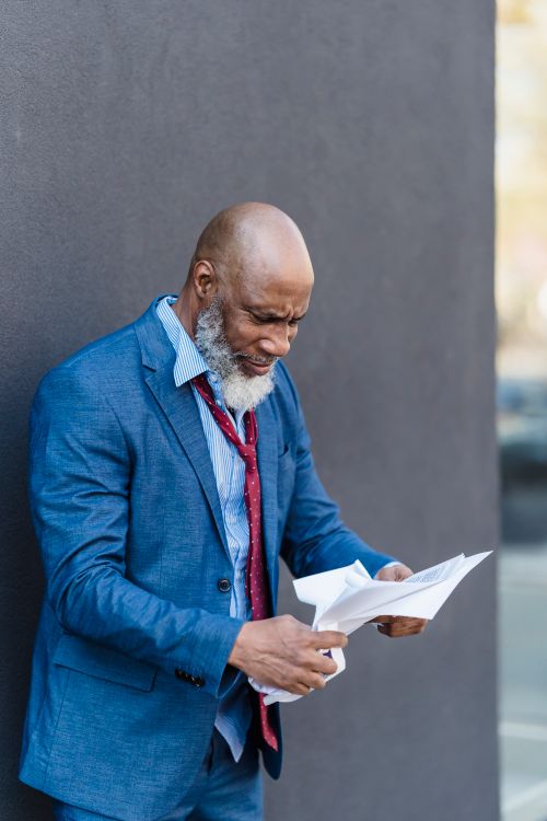 Businessman in a suit looking worried while reading documents