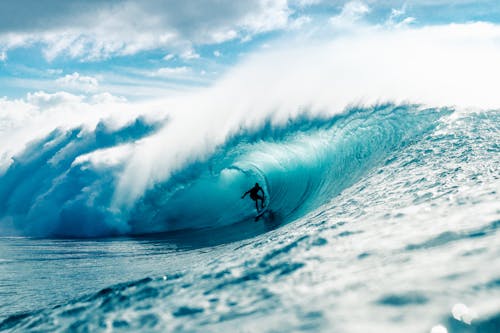 Free Man riding surfboard in wavy ocean Stock Photo