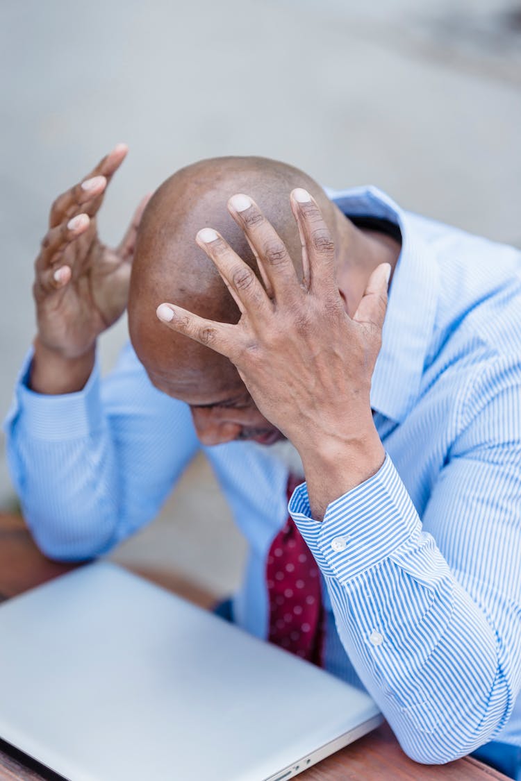 Stressed Black Man Touching Head And Looking Down