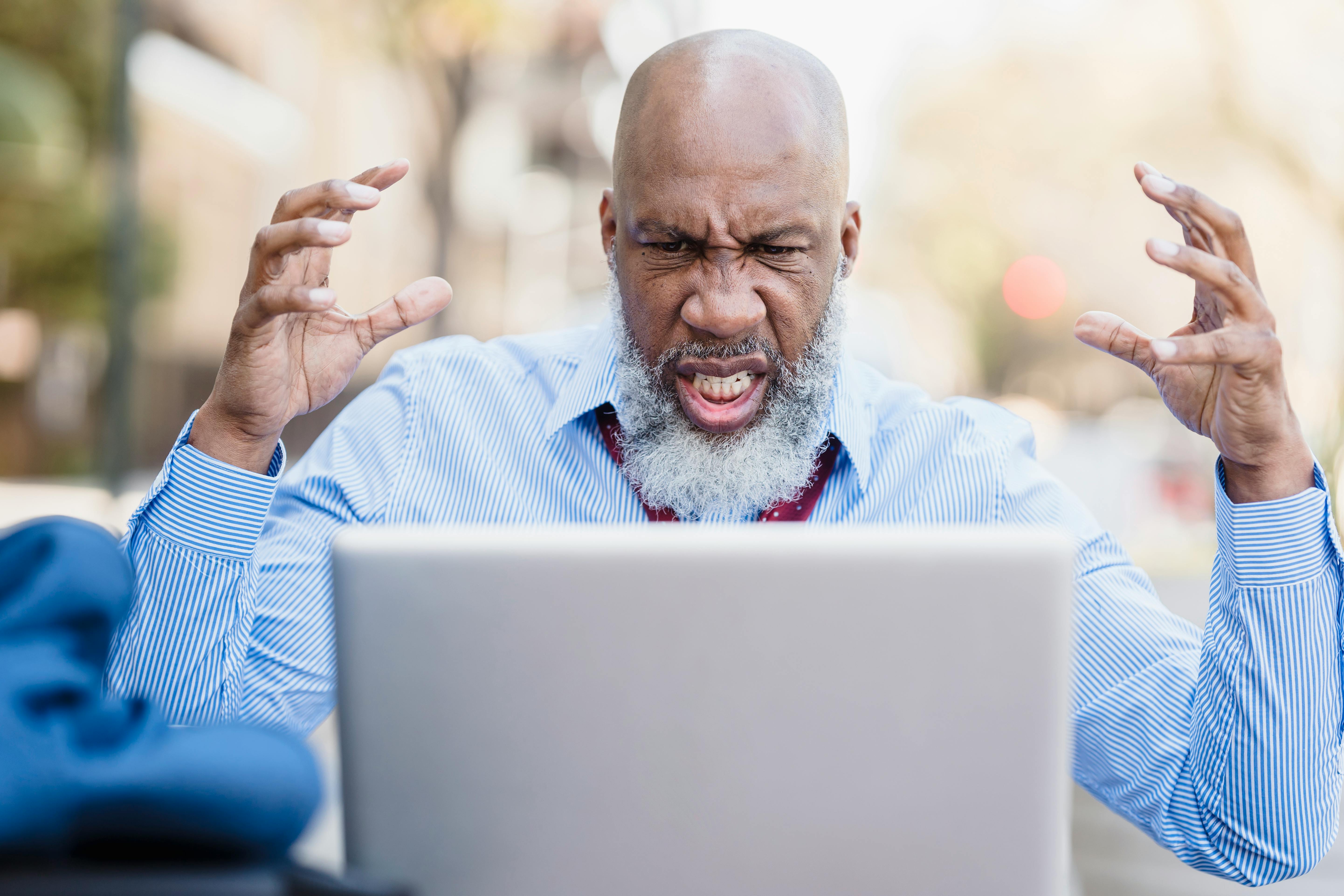 angry black man having video conversation via laptop