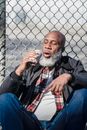 Drinking black male sitting near fence