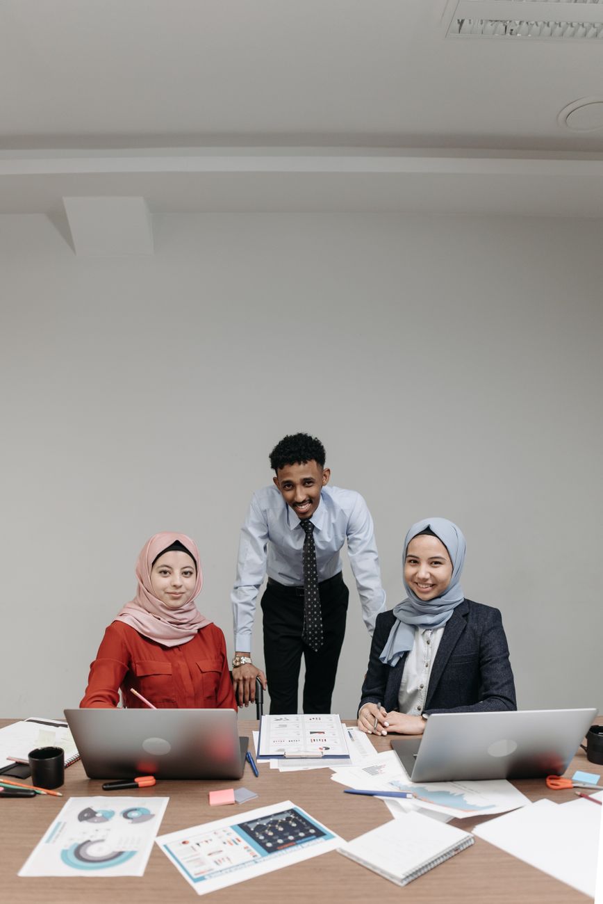 Three diverse colleagues collaborating in a modern office setting, promoting inclusivity.