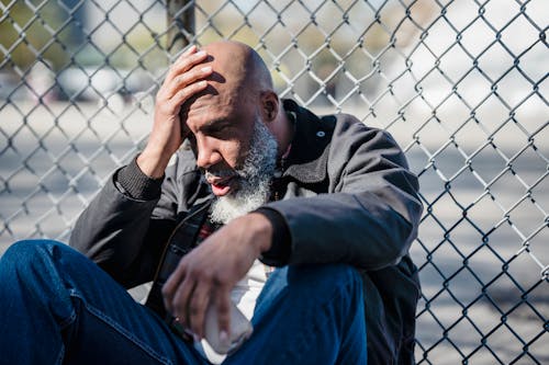 Sad Man by Fence