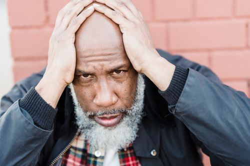 Free Portrait of a pensive senior man wearing a black jacket, expressing deep thought. Stock Photo