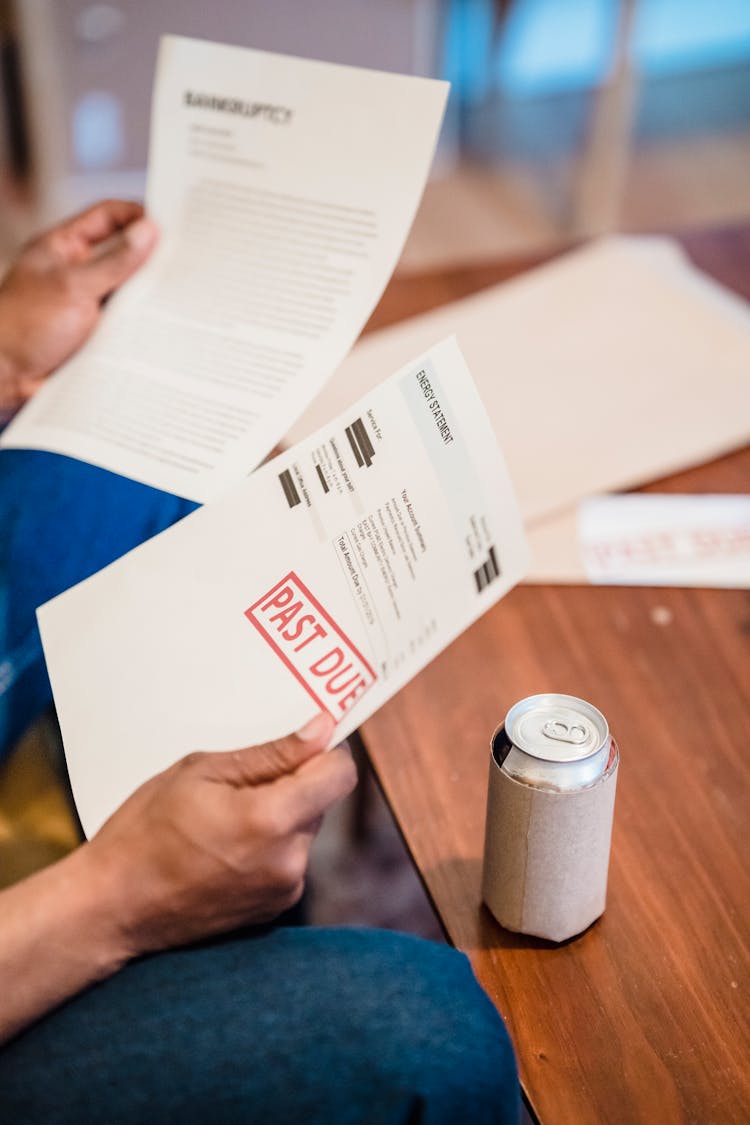 Close-up Of Person Reading Past Due Documents