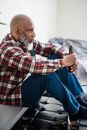 Man in Red White and Black Plaid Dress Shirt and Blue Denim Jeans Sitting on White