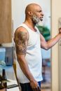 Man in White Tank Top With Black Tattoo on His Back