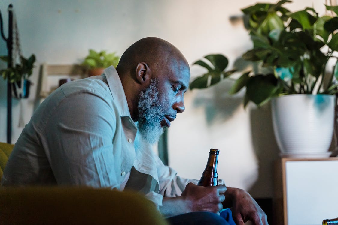 Free Old Man Sitting at Home Drinking Beer Stock Photo