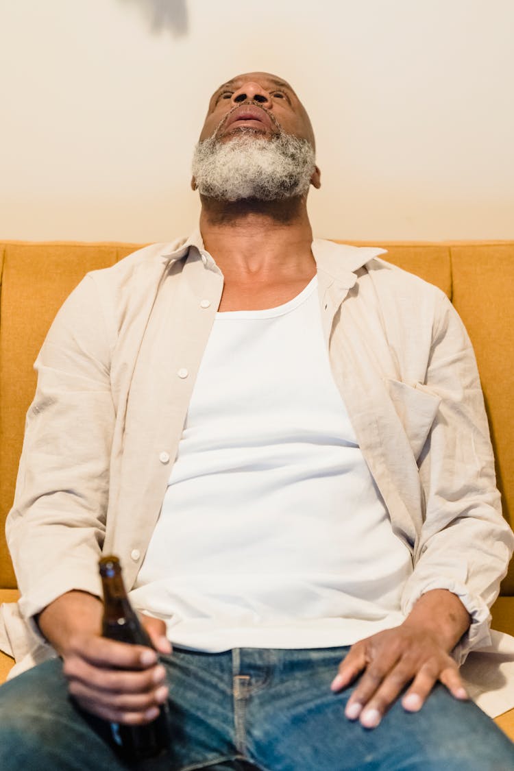 Man Sitting With Bottle And Staring At Ceiling