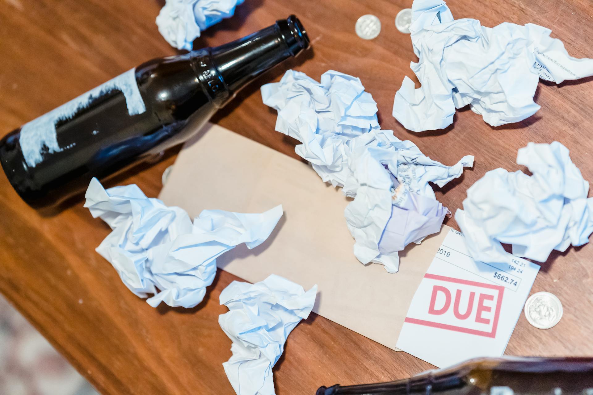 Past Due Notice and Beer Bottle on Table