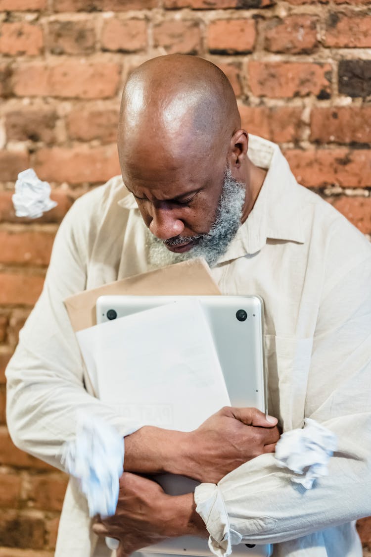 Unhappy Old Man With Laptop And Papers