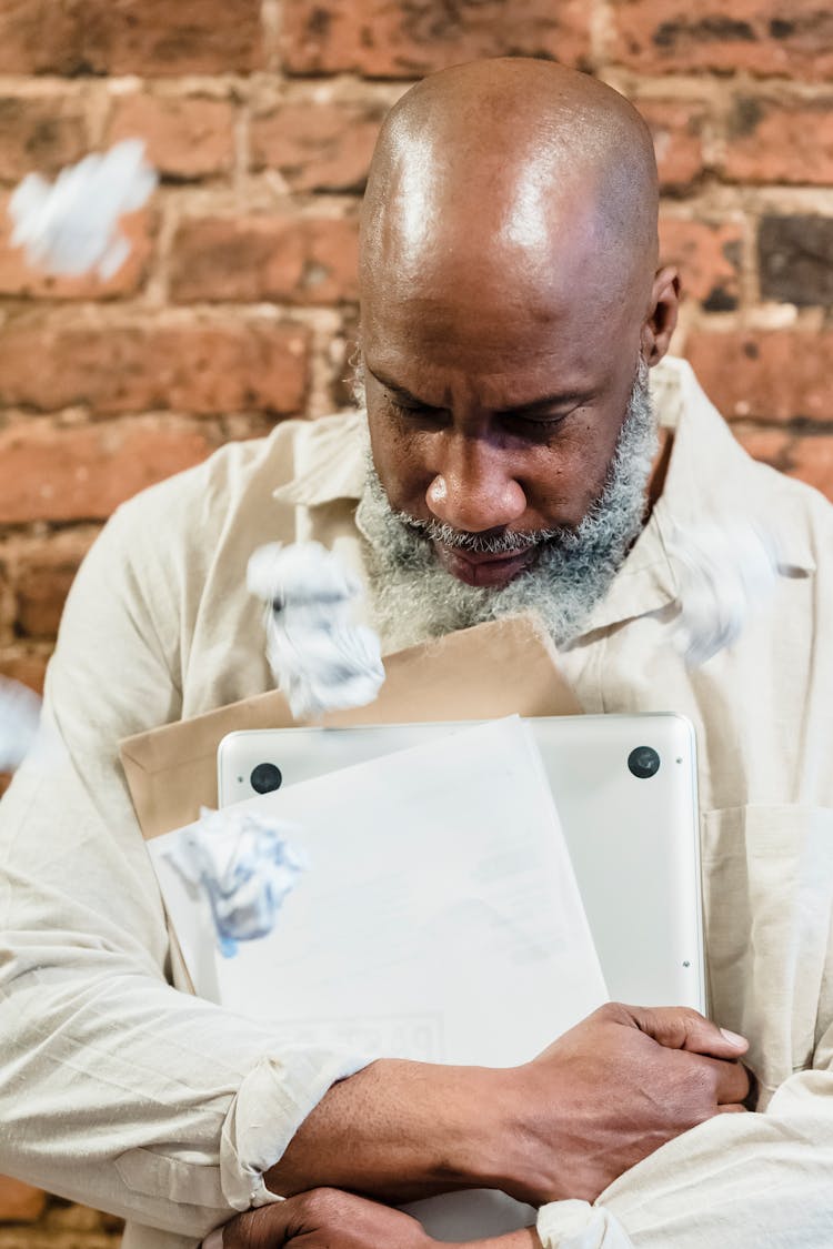 Unhappy Old Man With Paperwork And Computer