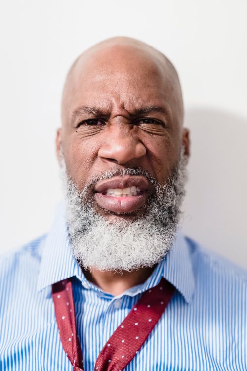 Free A close-up portrait of an African American man with a beard and bald head, expressing emotion. Stock Photo
