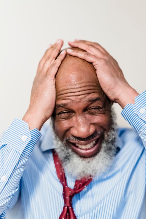 Free A frustrated African American man holds his head, expressing stress and worry. Stock Photo