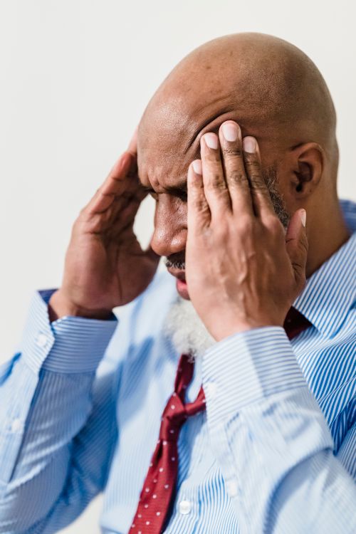 Free Adult bald man in shirt and tie holding head in stress, showing frustration. Stock Photo