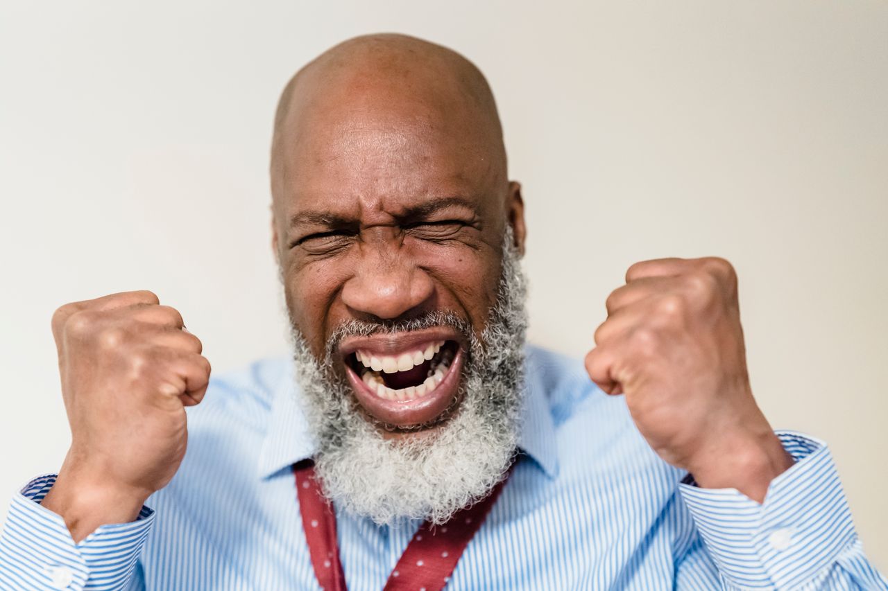 african american senior man showing excitement with clenched fists