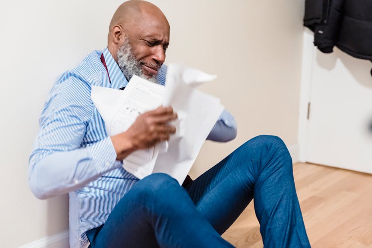 Stressed Old Man Throwing Paperwork At Home