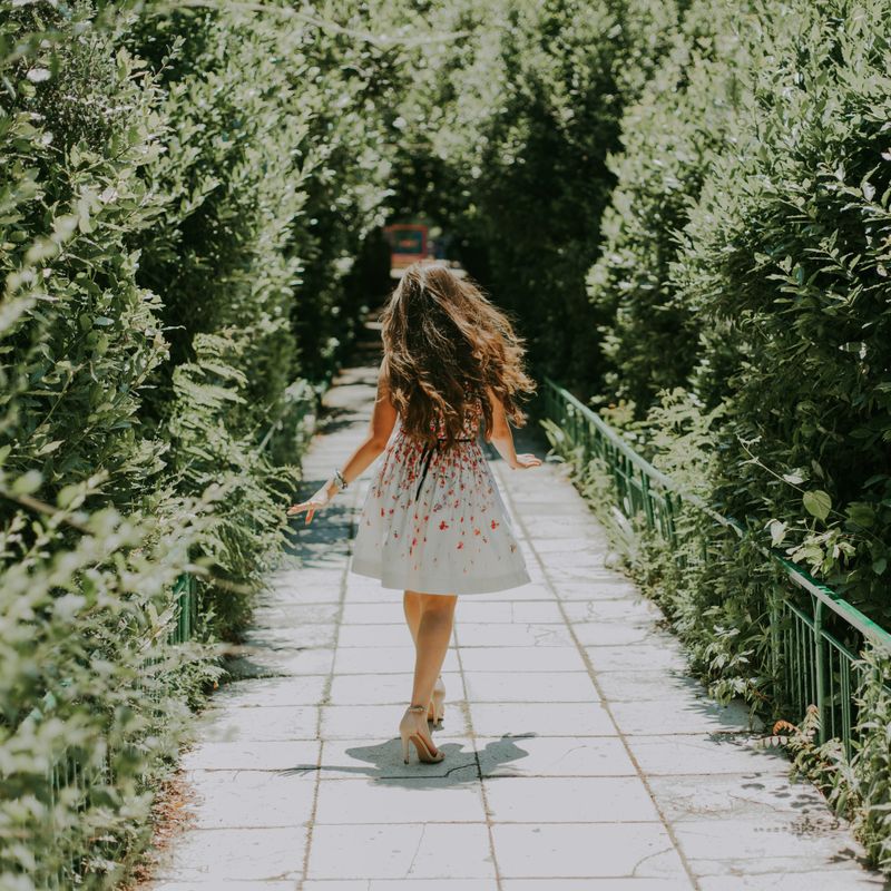 Woman in a white and red floral midi dress walking