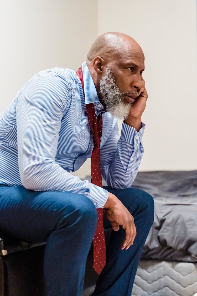 Unhappy Old Man In Suit Sitting Outdoors Thinking