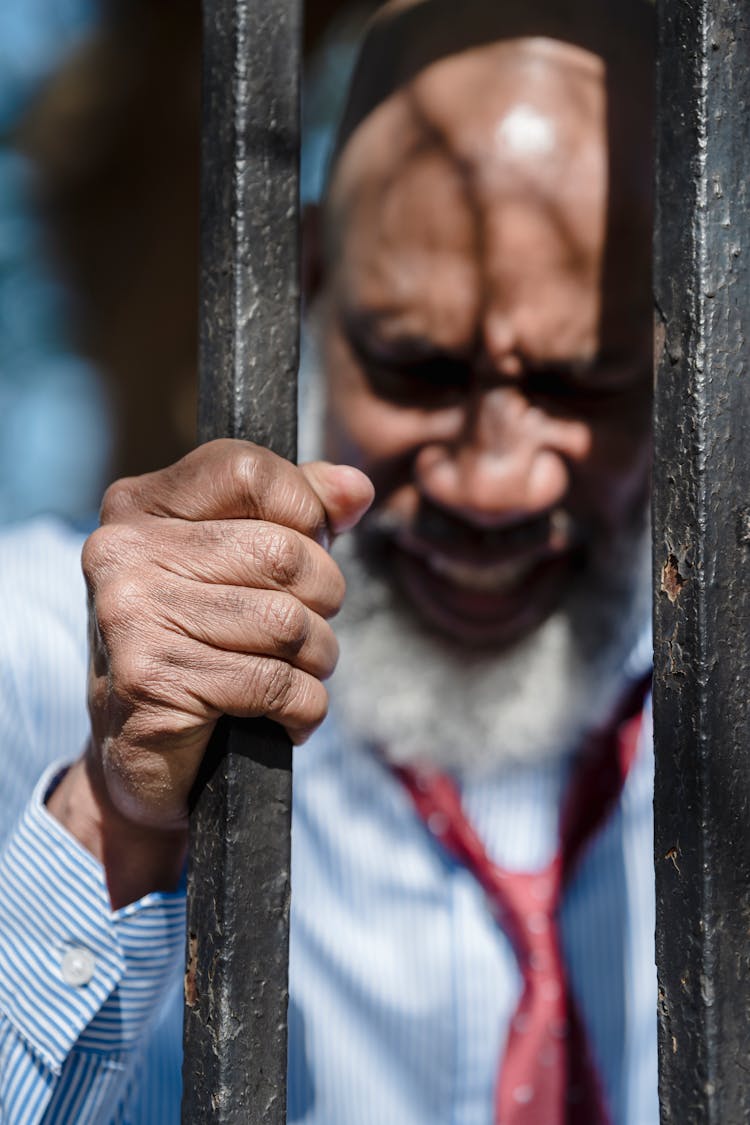 Stressed Old Man Behind Bars