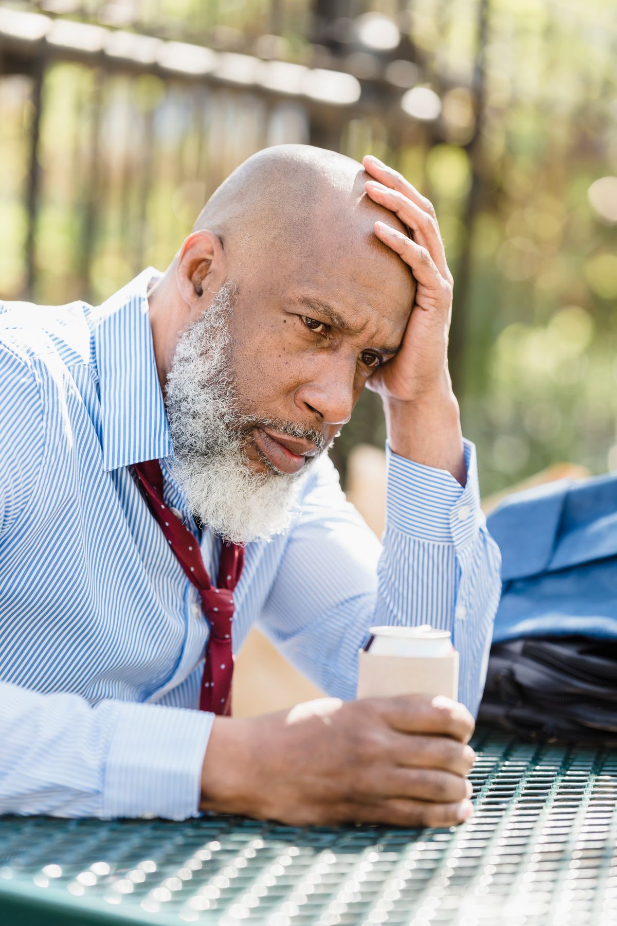 Person outdoors looking at a smartphone with a thoughtful expression
