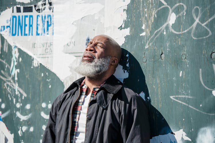 Distressed Elderly Man Near Old Wall