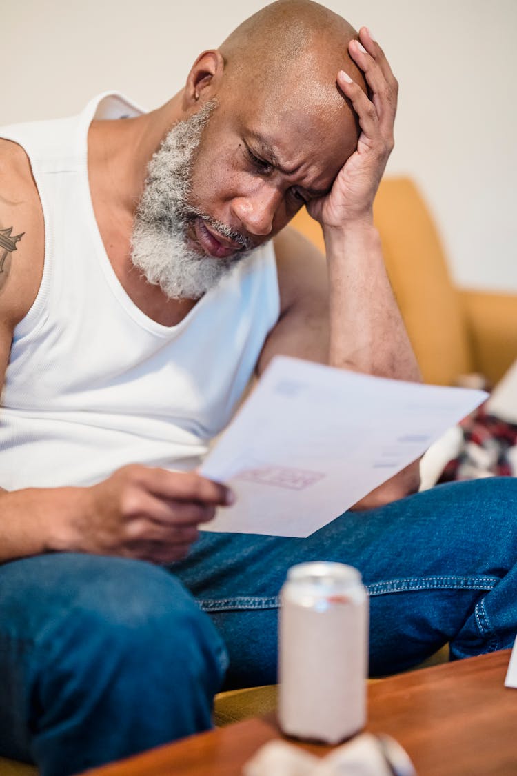 Stressed Old Man Reading Bad News In Letter