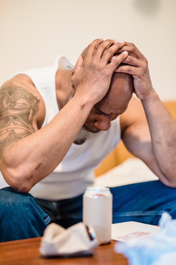 Depressed Man Holding Head In Hands