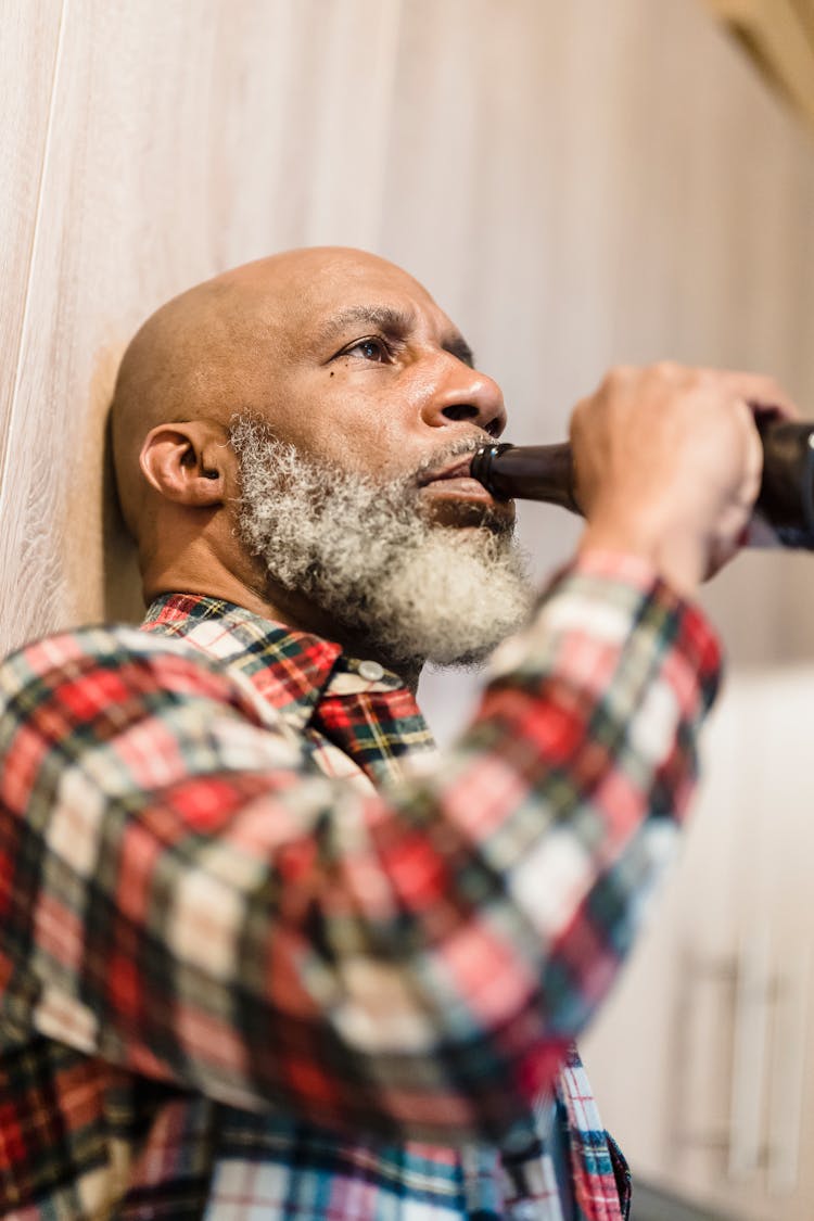 Old Bearded Man Drinking Beer From Bottle