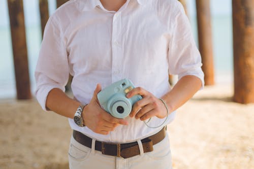 Man Holds Blue Fujufilm Instax Mini Camera