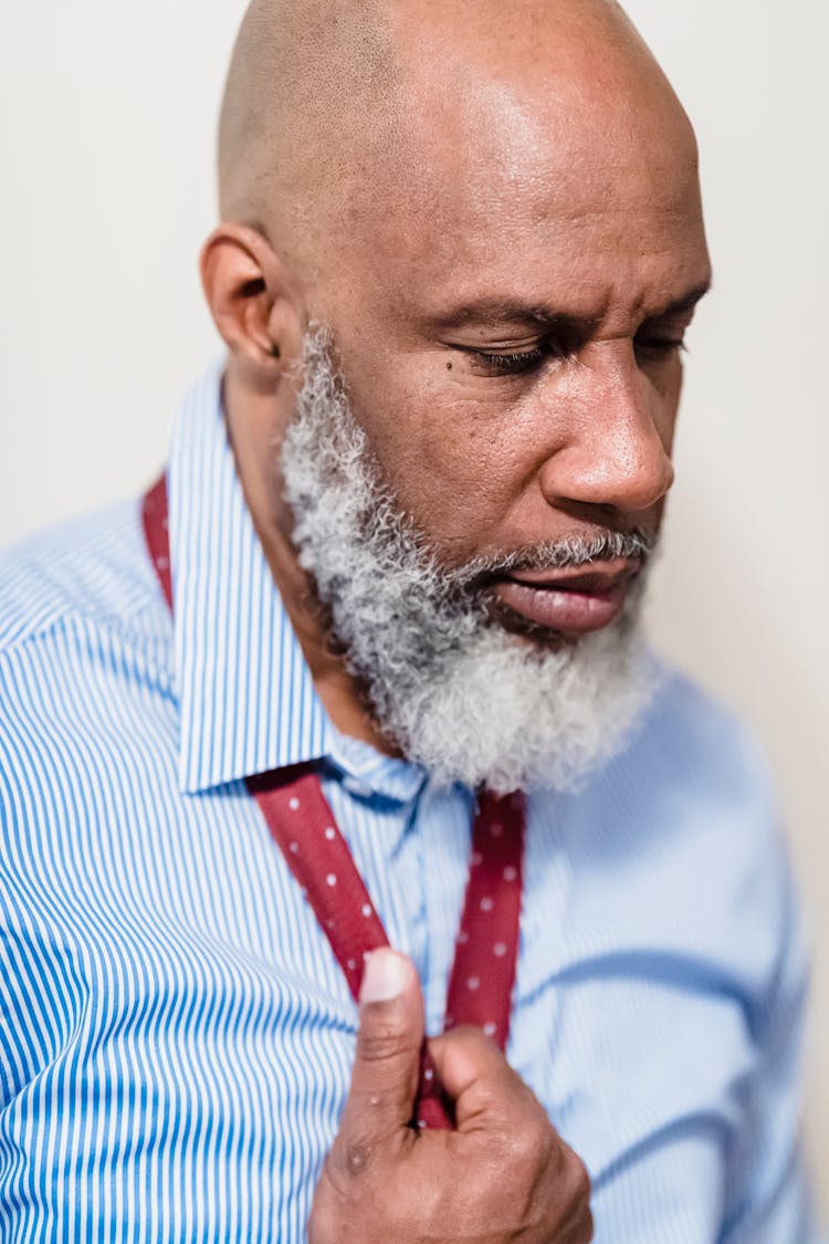 Portrait Of A Bearded Man Taking Off His Tie 