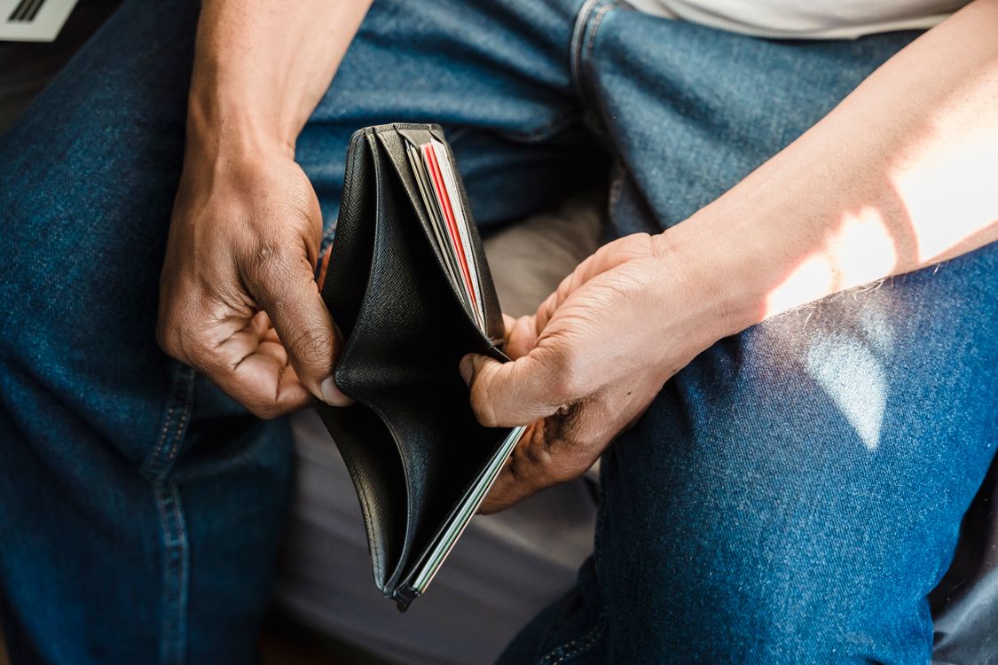 A man looking into an empty wallet
